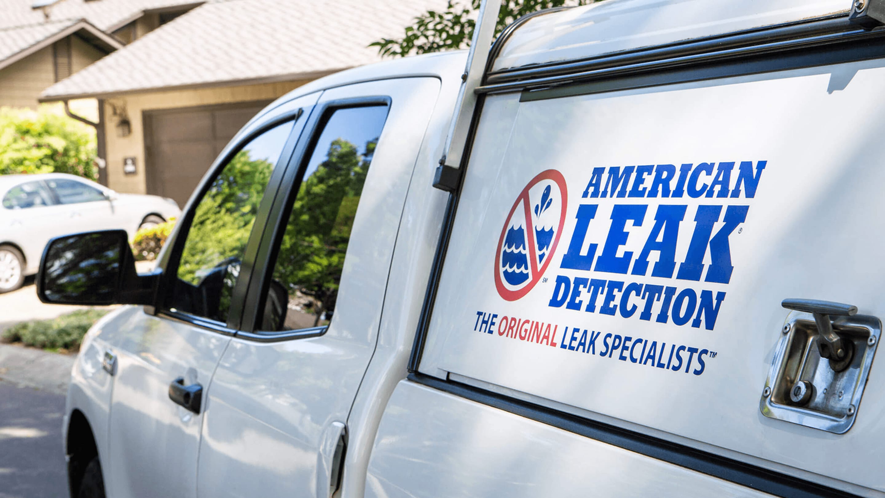 American Leak Detection branded service van parked in a residential driveway.