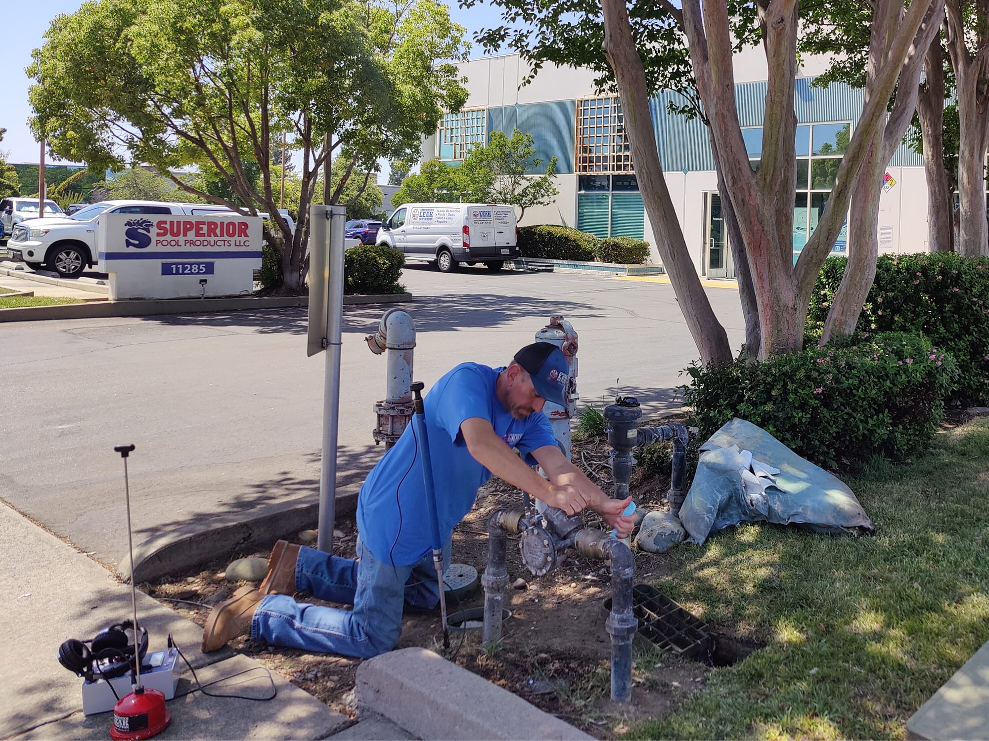 American Leak Detection technician testing an exterior commercial backflow assembly.